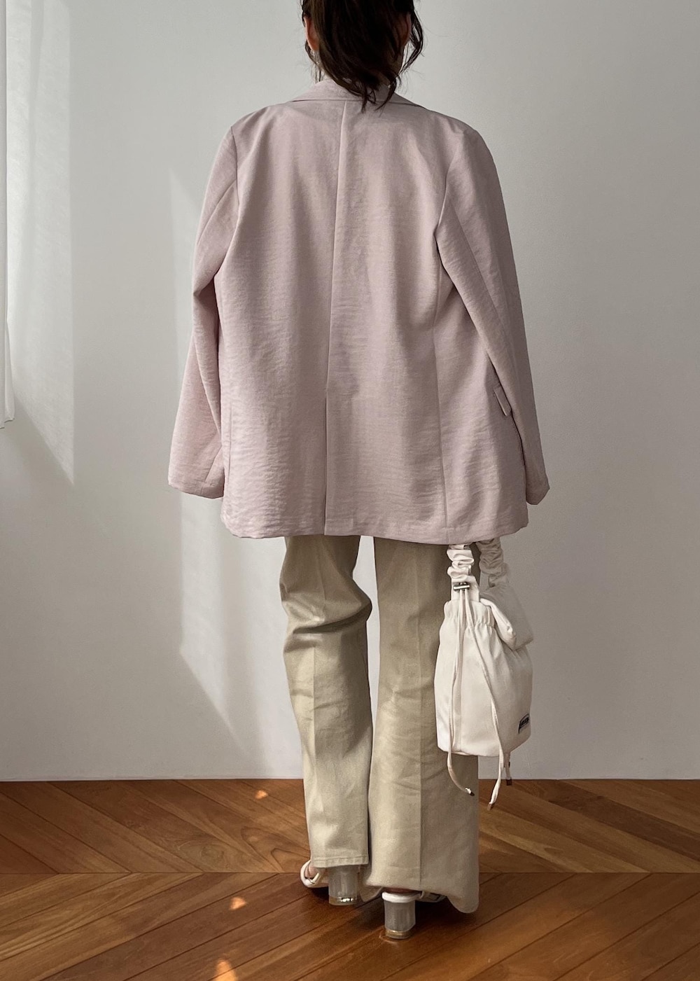 ホワイト系のショルダーバッグ、ピンク系のテーラードジャケット、ベージュ系のデニムパンツを着用したレディースの春コーディネートの8枚目の写真