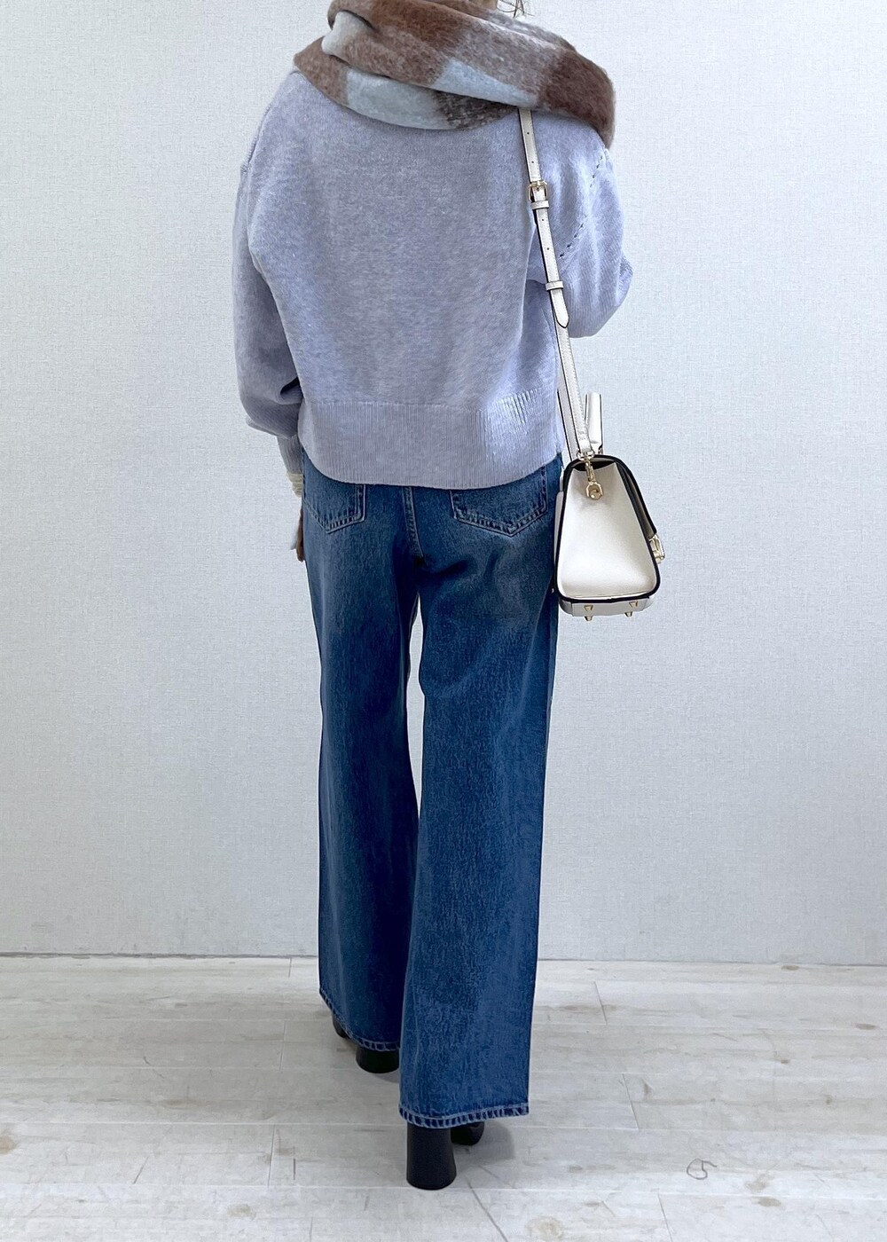 パープル系のカーディガン/ボレロ、ホワイト系のTシャツ/カットソー、ブラック系のブーツを着用したレディースの秋コーディネートの4枚目の写真