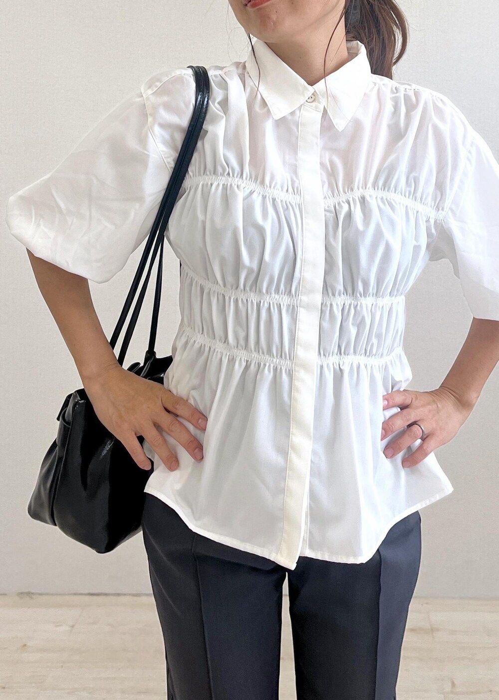 シルバー系のパンプス、ブラック系のショルダーバッグ、グレー系のスラックスを着用したレディースの秋コーディネートの6枚目の写真