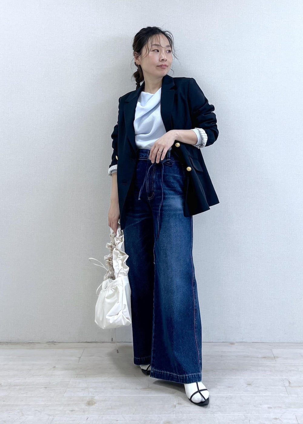 ブルー系のテーラードジャケット、ブルー系のデニムパンツ、ホワイト系のショルダーバッグを着用したレディースの冬コーディネートの10枚目の写真