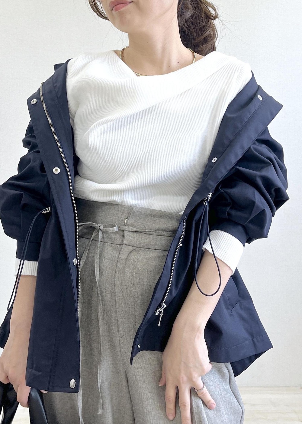 ブラック系のトートバッグ、ブルー系のナイロンジャケット、グレー系のその他パンツを着用したレディースの春コーディネートの7枚目の写真