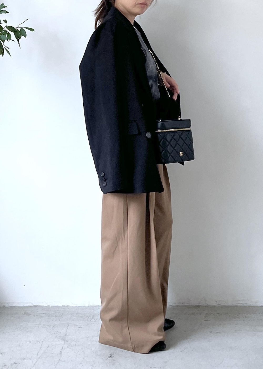 ブラック系のテーラードジャケット、ホワイト系のTシャツ/カットソー、ブラック系のパンプスを着用したレディースの秋コーディネートの3枚目の写真