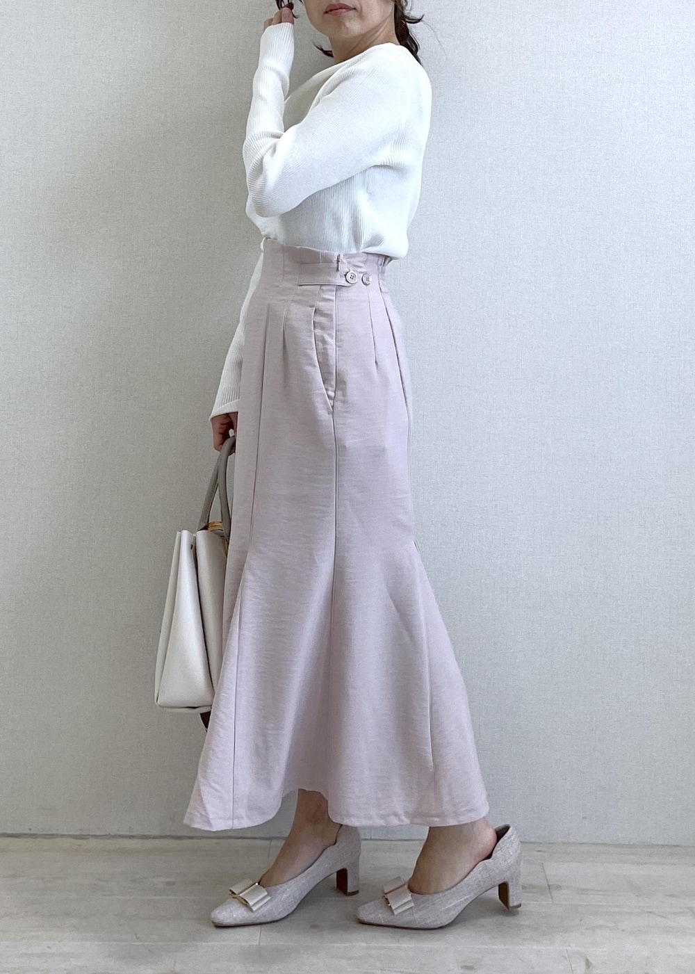 ベージュ系のパンプス、ホワイト系のニット/セーター、ピンク系のスカートを着用したレディースの春コーディネートの4枚目の写真