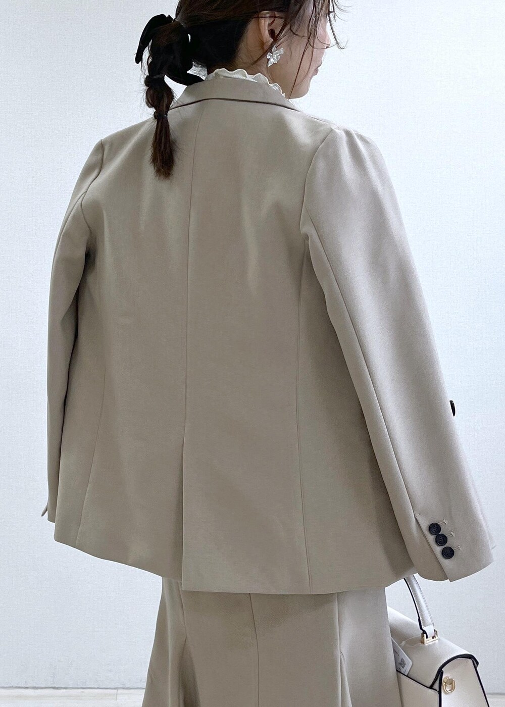 ブラック系のブーツ、ベージュ系のスカート、パープル系のカーディガン/ボレロを着用したレディースの秋コーディネートの5枚目の写真