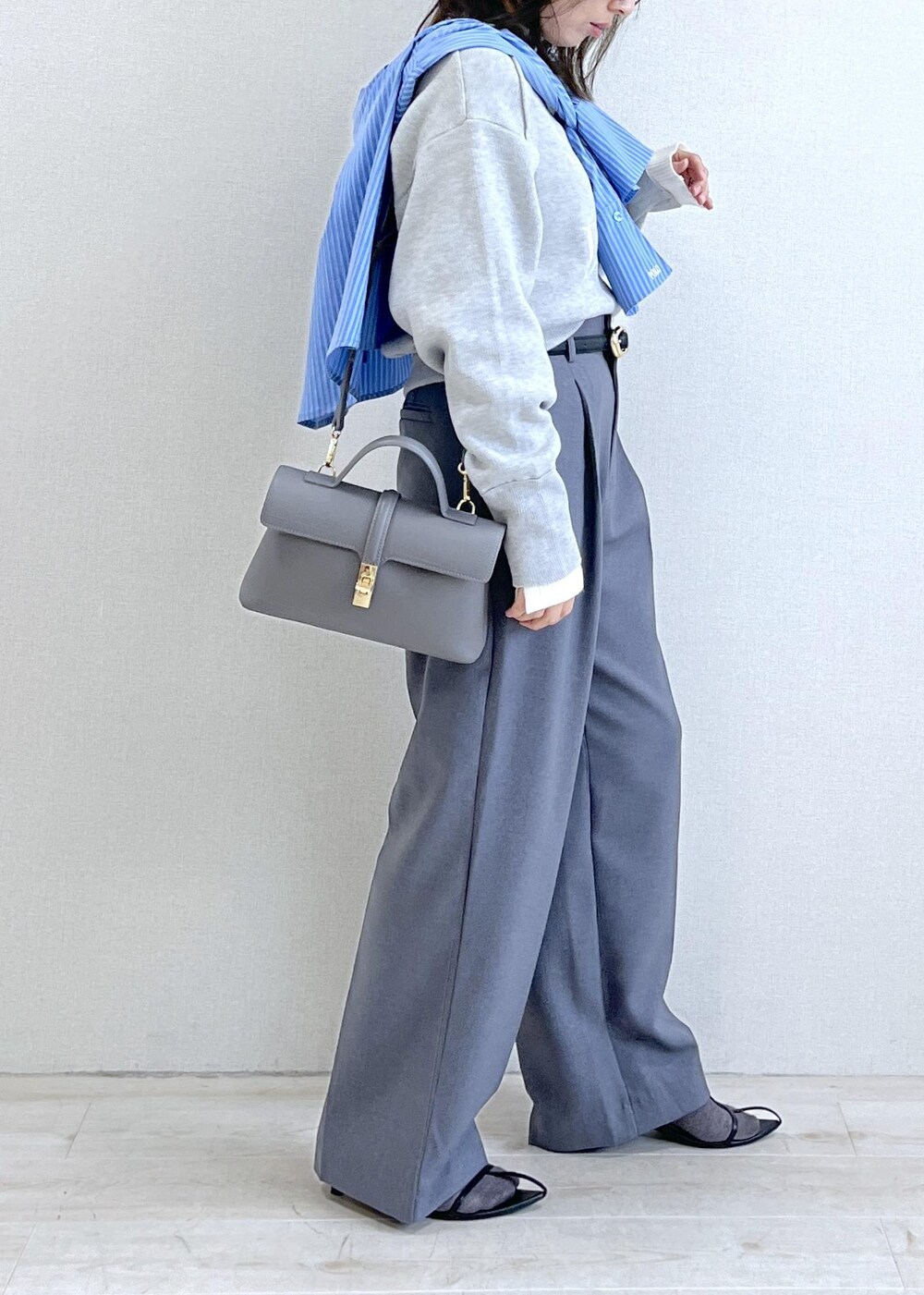 グレー系のショルダーバッグ、グレー系のスラックス、ブルー系のシャツ/ブラウスを着用したレディースの秋コーディネートの4枚目の写真
