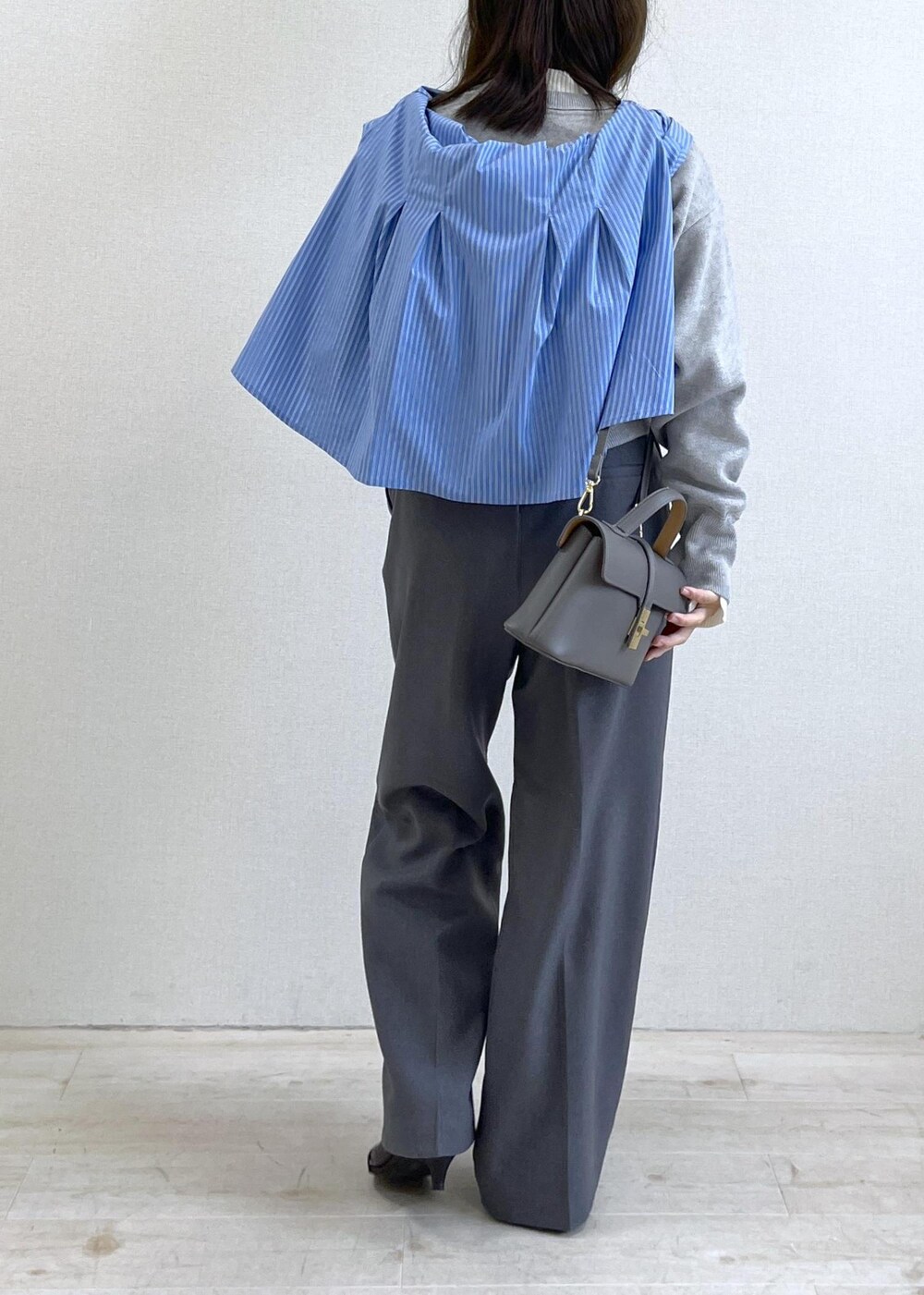 グレー系のショルダーバッグ、グレー系のスラックス、ブルー系のシャツ/ブラウスを着用したレディースの秋コーディネートの5枚目の写真