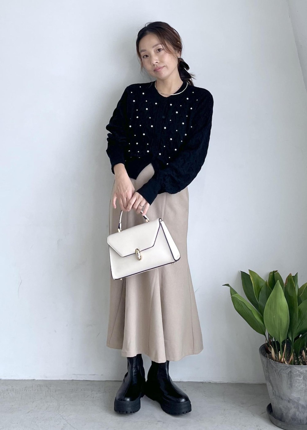 ブラック系のブーツ、ベージュ系のスカート、ブラック系のカーディガン/ボレロを着用したレディースの秋コーディネートの10枚目の写真