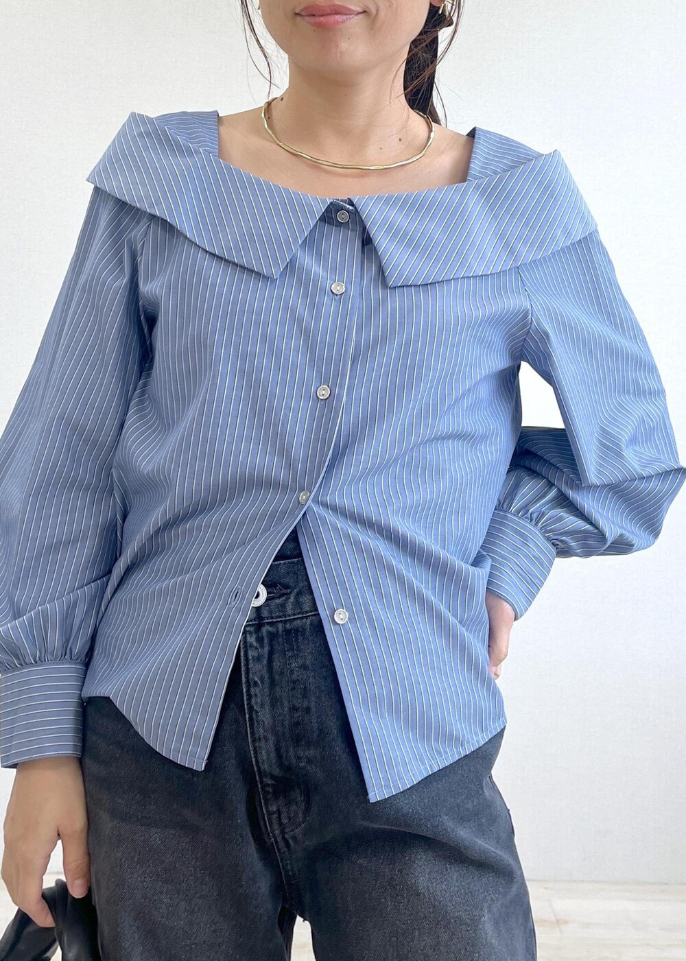 ブルー系のシャツ/ブラウス、グレー系のデニムパンツ、ブラック系のハンドバッグを着用したレディースの秋コーディネートの4枚目の写真