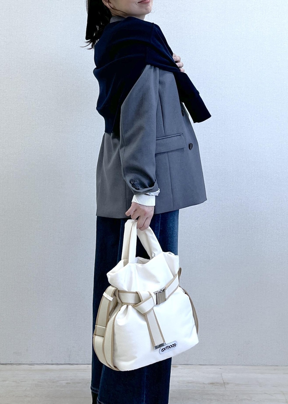 グレー系のテーラードジャケット、ブルー系のデニムパンツ、ホワイト系のニット/セーターを着用したレディースの冬コーディネートの4枚目の写真