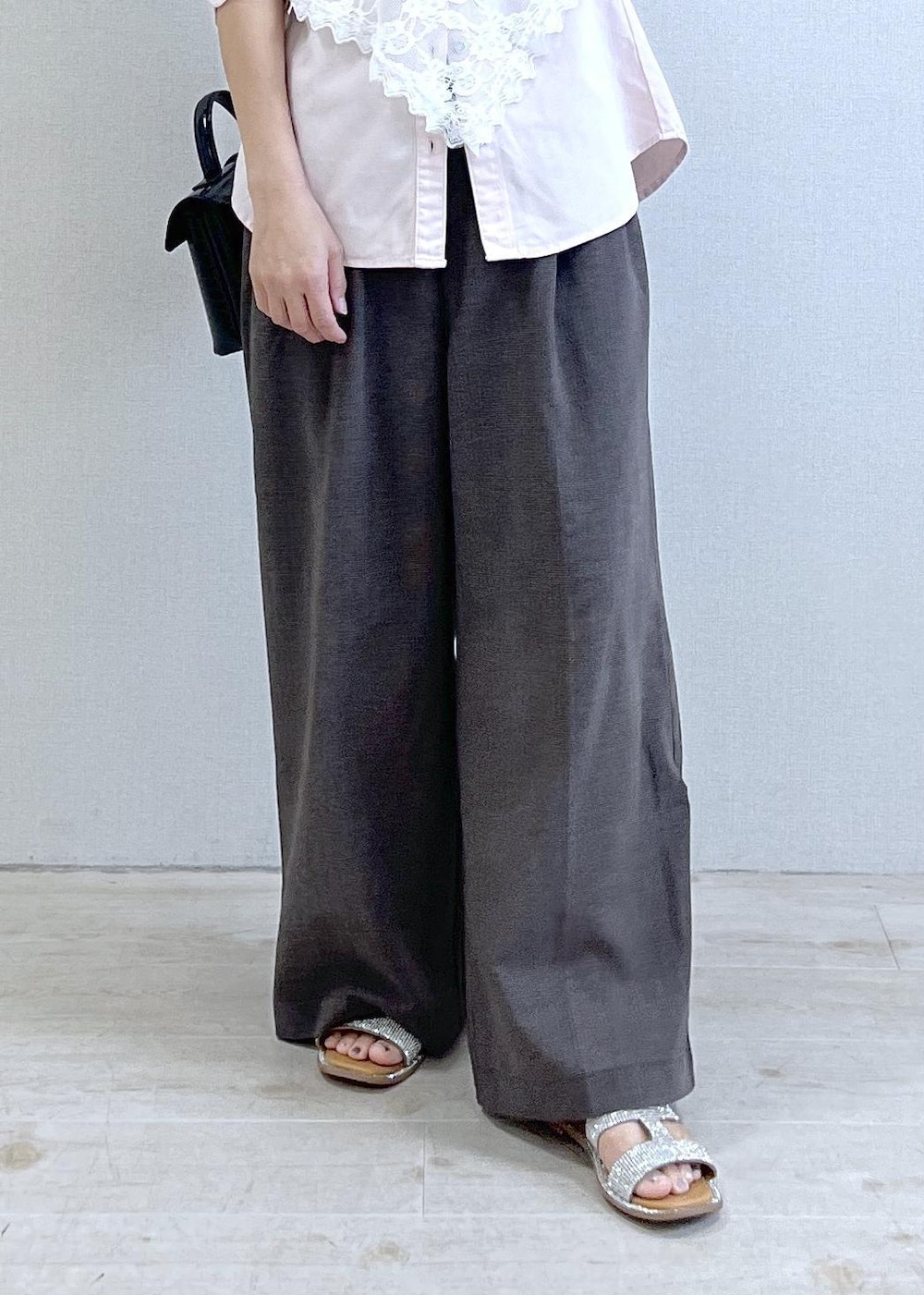ピンク系のシャツ/ブラウス、ブラウン系のその他パンツ、ブラック系のハンドバッグを着用したレディースの夏コーディネートの3枚目の写真