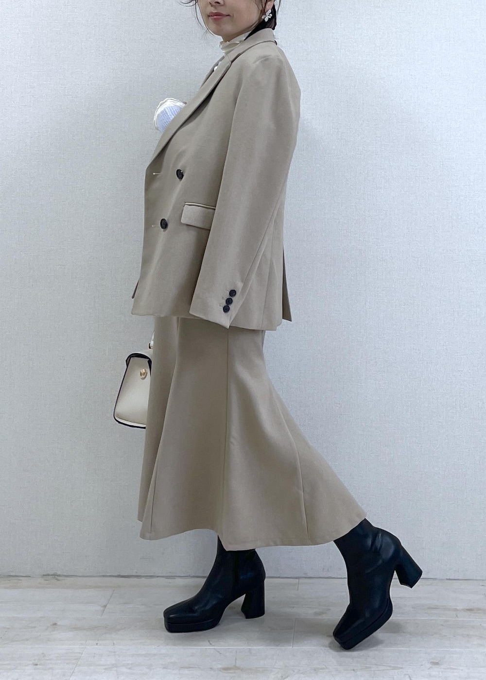 ブラック系のブーツ、ベージュ系のスカート、パープル系のカーディガン/ボレロを着用したレディースの秋コーディネートの3枚目の写真