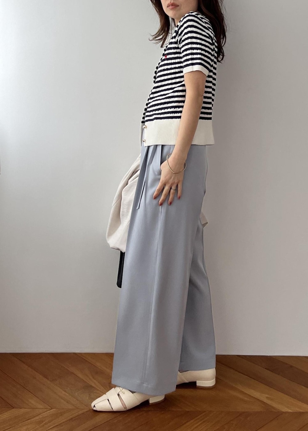 ブラック系のショルダーバッグ、ホワイト系のパンプス、ブルー系のその他パンツを着用したレディースの春コーディネートの7枚目の写真