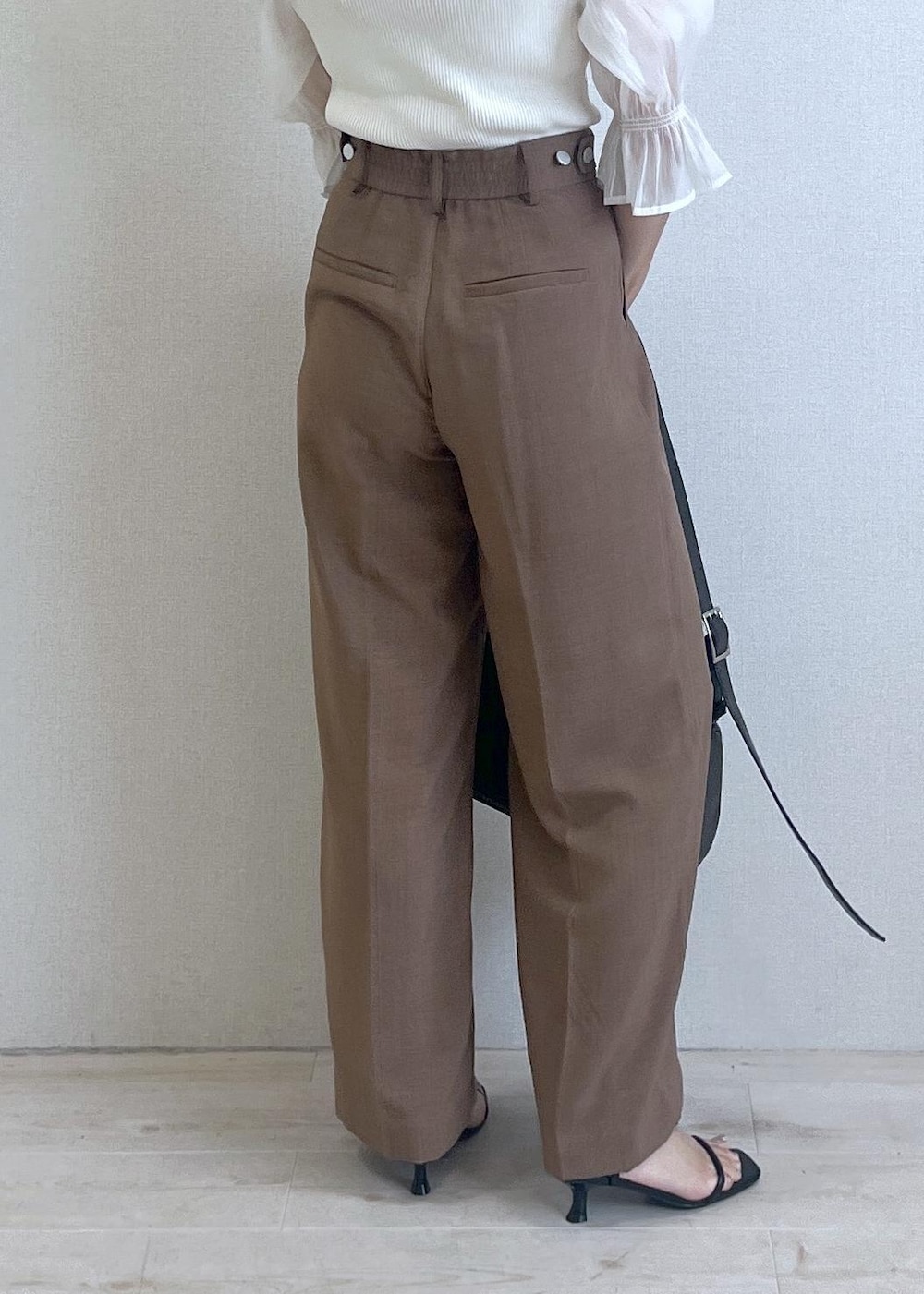 ブラック系のショルダーバッグ、ブラック系のサンダル、ブラウン系のテーラードジャケットを着用したレディースの夏コーディネートの4枚目の写真