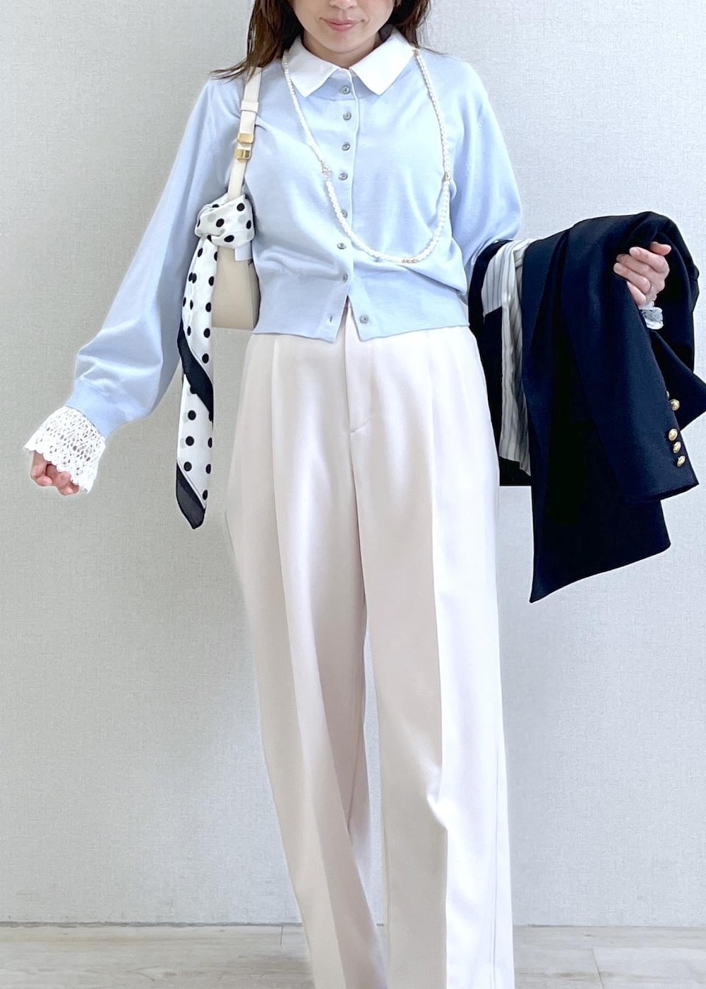 ホワイト系のショルダーバッグ、ブルー系のテーラードジャケット、ベージュ系のその他パンツを着用したレディースの春コーディネートの8枚目の写真
