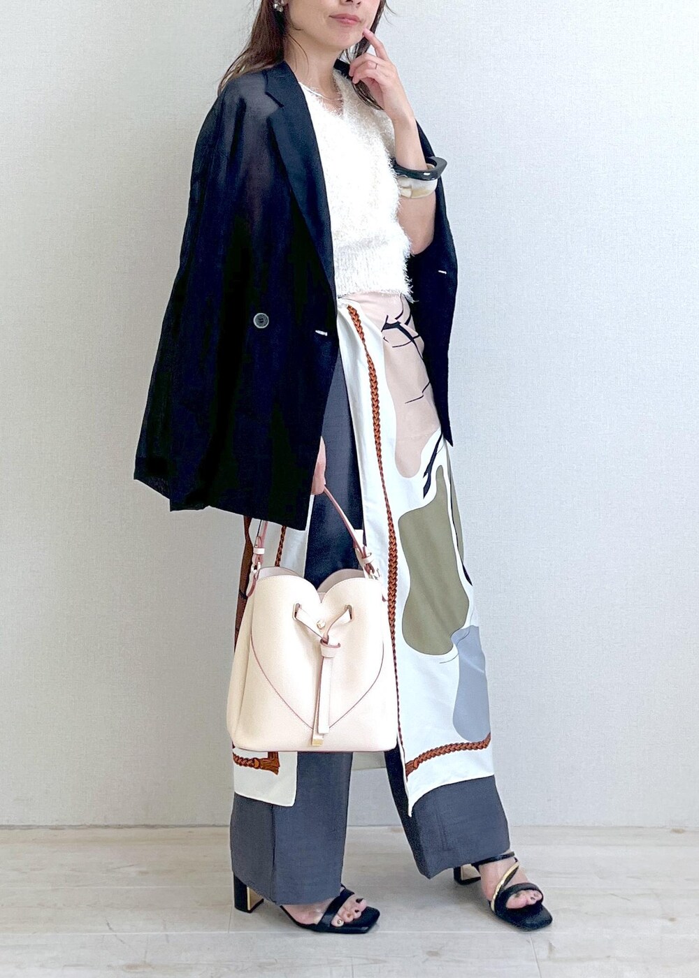 ベージュ系のショルダーバッグ、ブラック系のサンダル、ブラック系のテーラードジャケットを着用したレディースの夏コーディネートの10枚目の写真