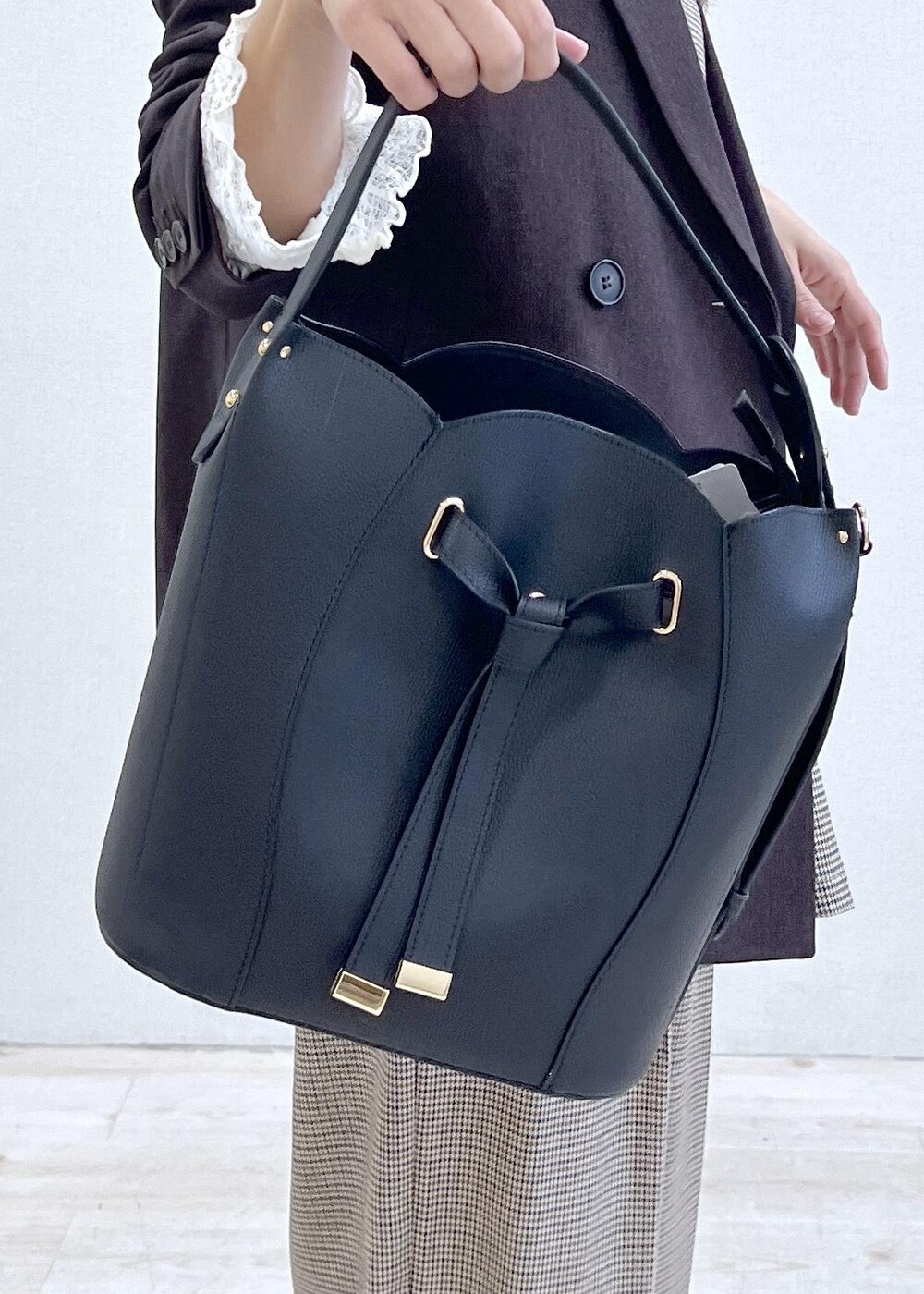 ベージュ系のスラックス、ブラウン系のテーラードジャケット、ベージュ系のキャミソールを着用したレディースの秋コーディネートの6枚目の写真