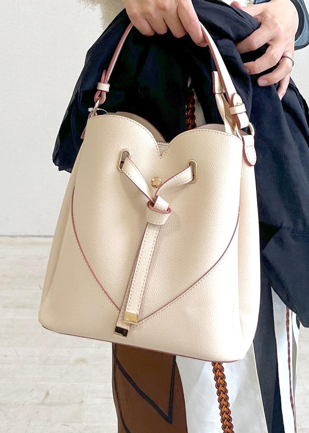 ベージュ系のショルダーバッグ、ブラック系のサンダル、ブラック系のテーラードジャケットを着用したレディースの夏コーディネートの6枚目の写真