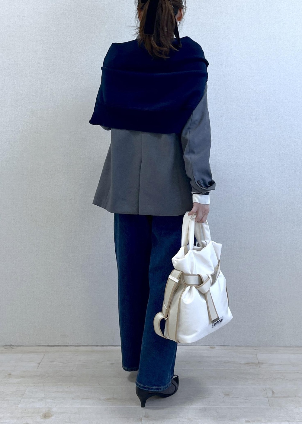 グレー系のテーラードジャケット、ブルー系のデニムパンツ、ホワイト系のニット/セーターを着用したレディースの冬コーディネートの7枚目の写真