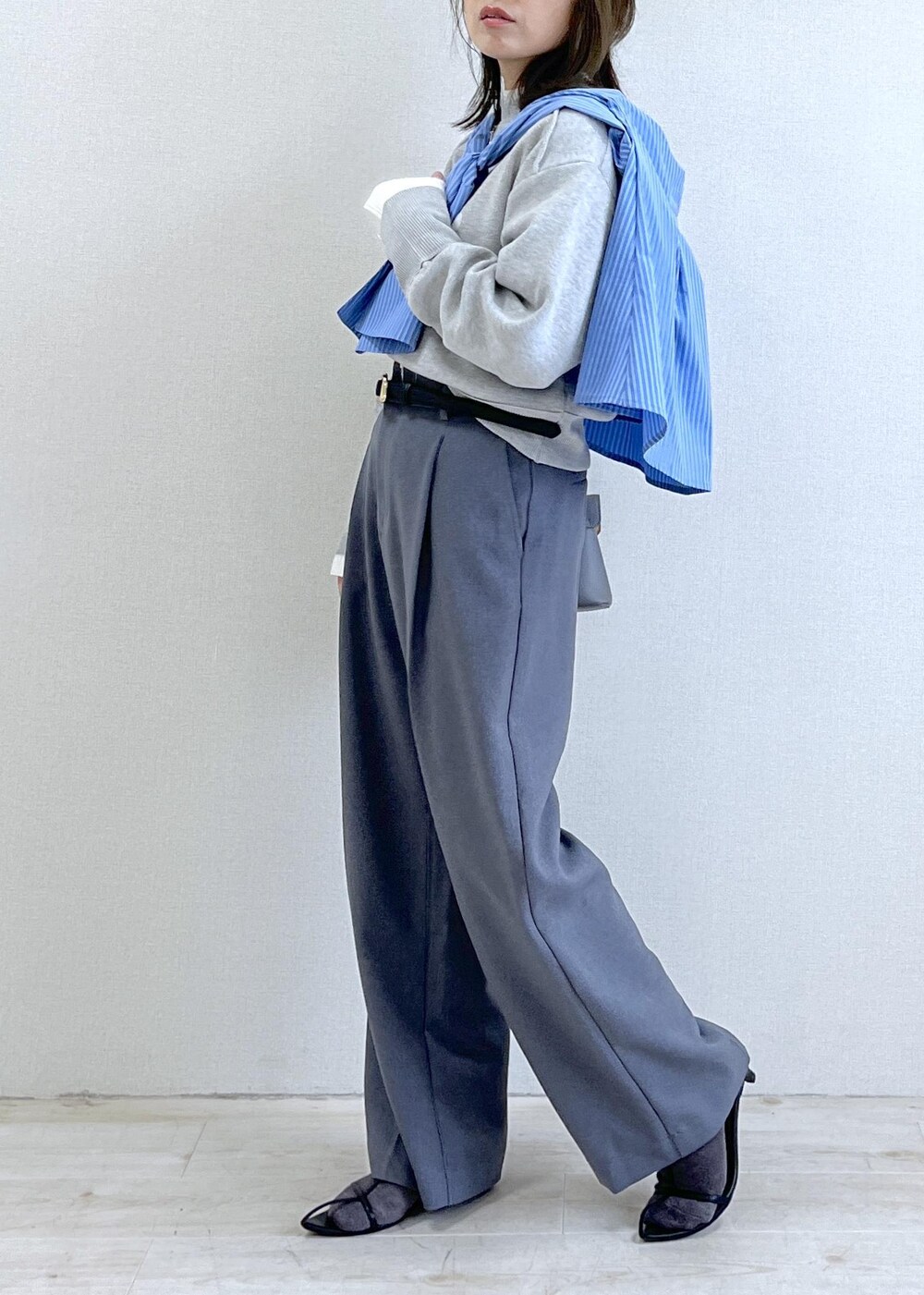 グレー系のショルダーバッグ、グレー系のスラックス、ブルー系のシャツ/ブラウスを着用したレディースの秋コーディネートの3枚目の写真