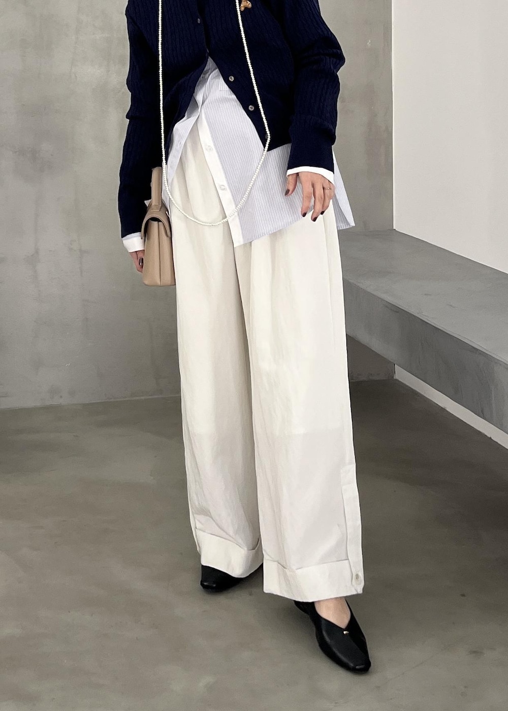 ベージュ系のショルダーバッグ、ブラック系のパンプス、ホワイト系のその他パンツを着用したレディースの冬コーディネートの6枚目の写真