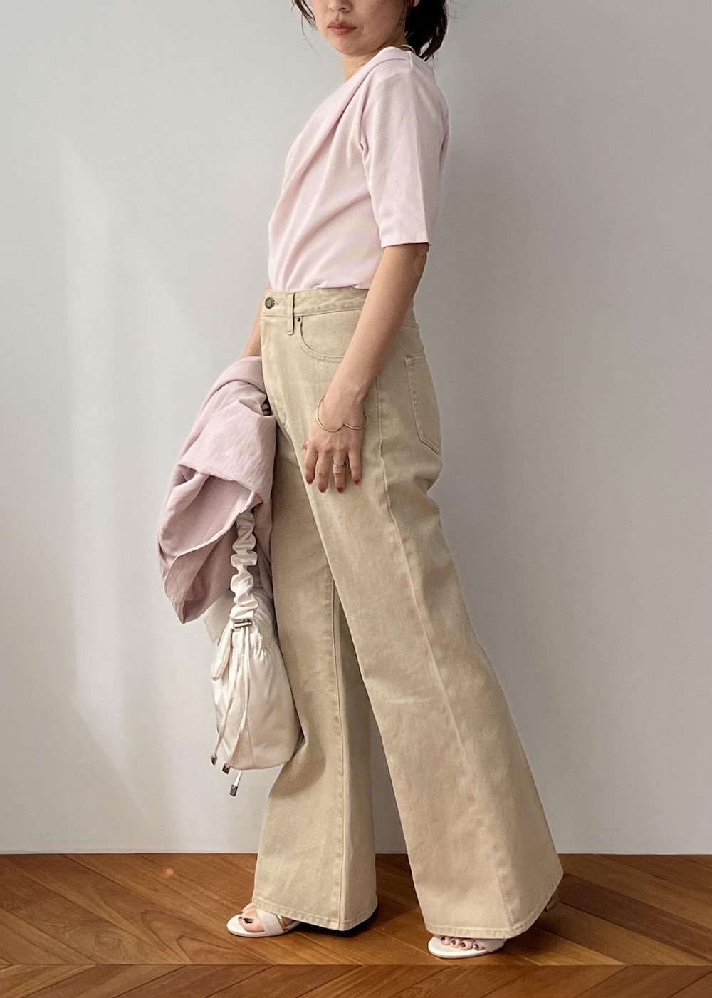 ホワイト系のショルダーバッグ、ピンク系のテーラードジャケット、ベージュ系のデニムパンツを着用したレディースの春コーディネートの3枚目の写真