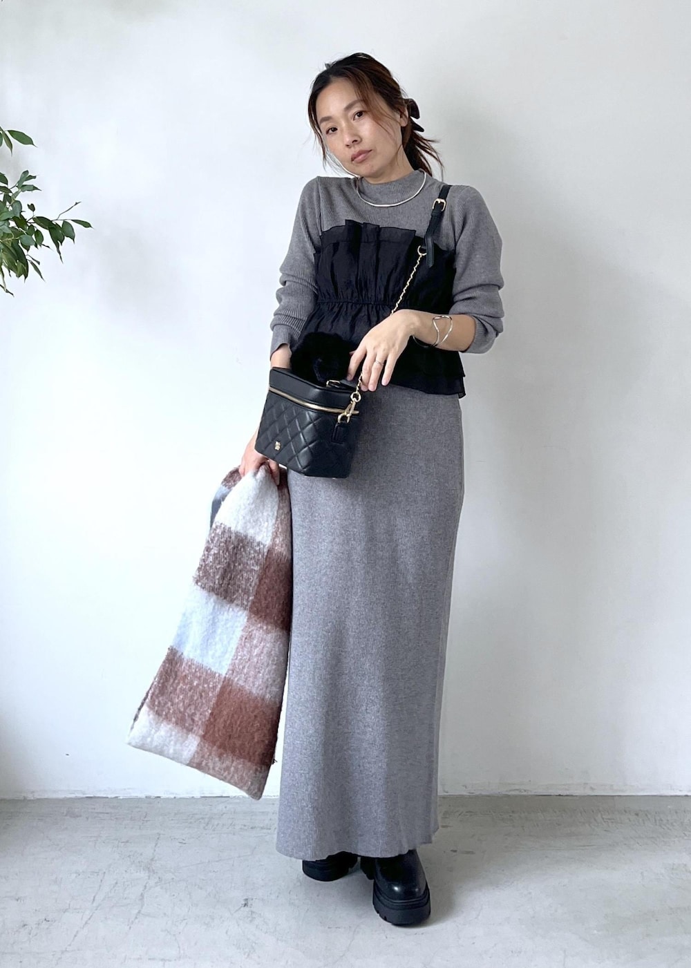 ブラック系のブーツ、グレー系のスカート、グレー系のニット/セーターを着用したレディースの秋コーディネートの10枚目の写真