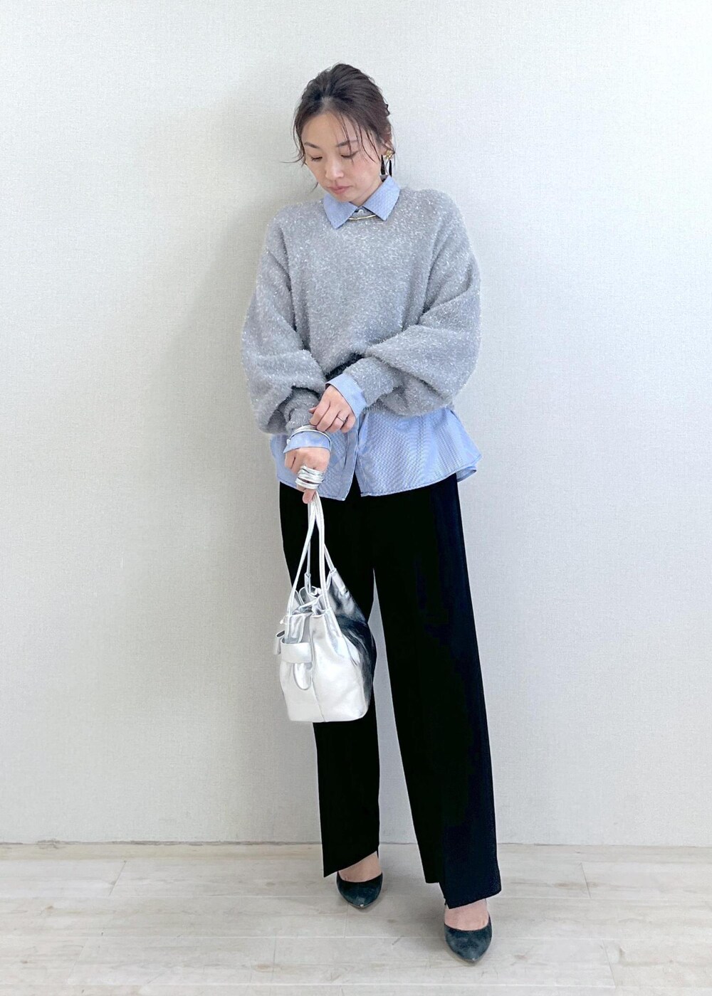 シルバー系のショルダーバッグ、ブラック系のスラックス、ブルー系のシャツ/ブラウスを着用したレディースの冬コーディネートの2枚目の写真