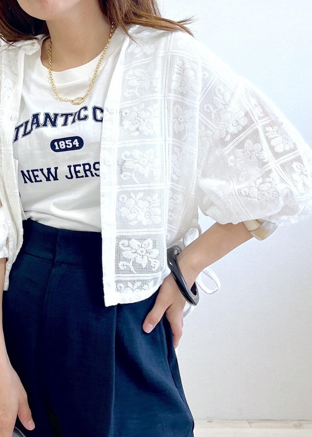 シルバー系のショルダーバッグ、ホワイト系のTシャツ/カットソー、ホワイト系のサンダルを着用したレディースの春コーディネートの5枚目の写真