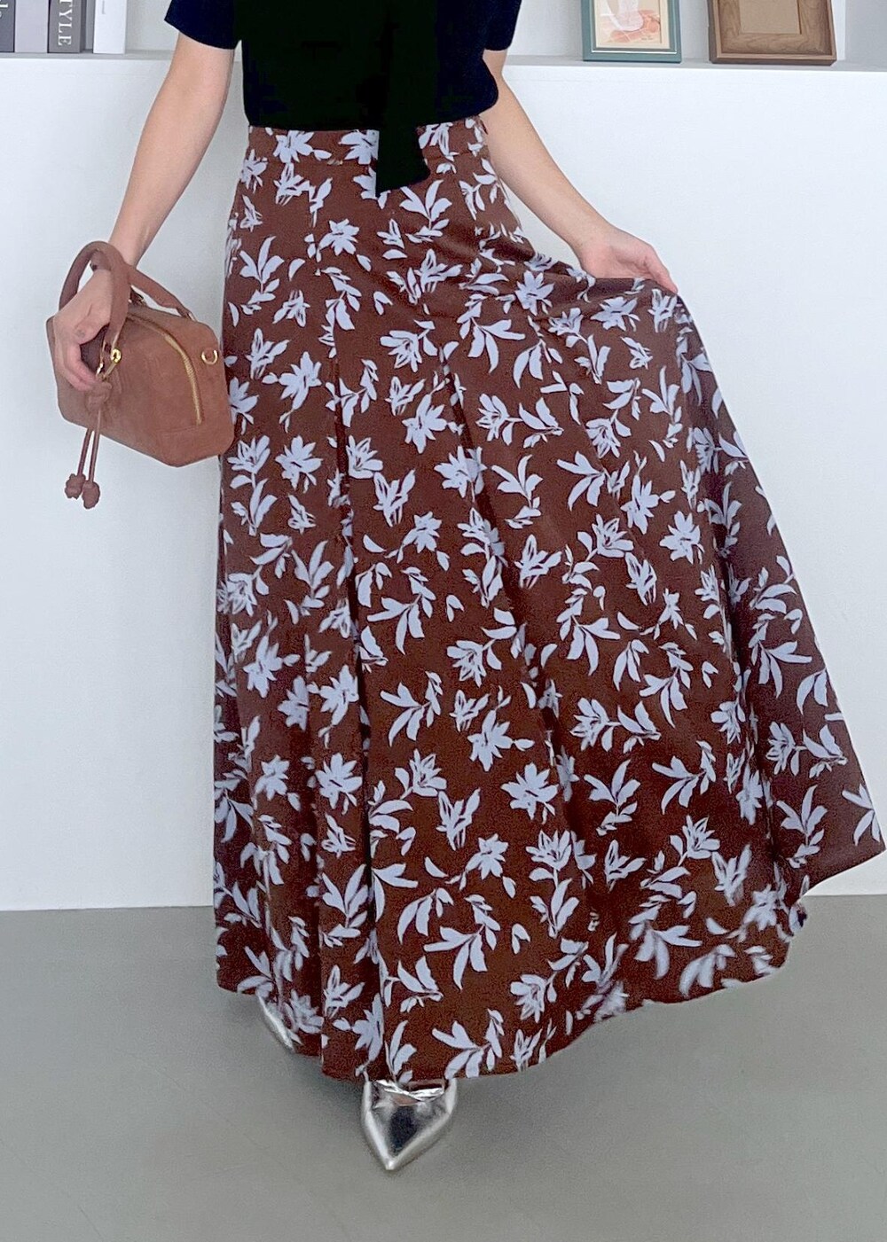 シルバー系のパンプス、ブラウン系のボストンバッグ、ブラウン系のスカートを着用したレディースの夏コーディネートの5枚目の写真