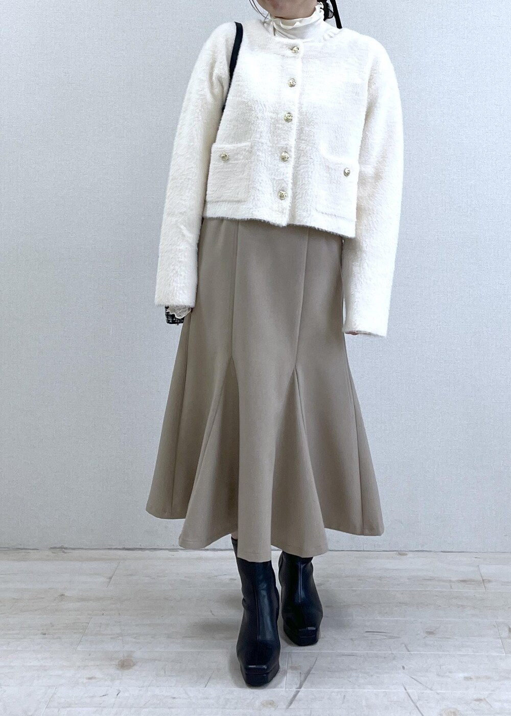 ベージュ系のスカート、ホワイト系のカーディガン/ボレロ、ホワイト系のTシャツ/カットソーを着用したレディースの秋コーディネートの6枚目の写真