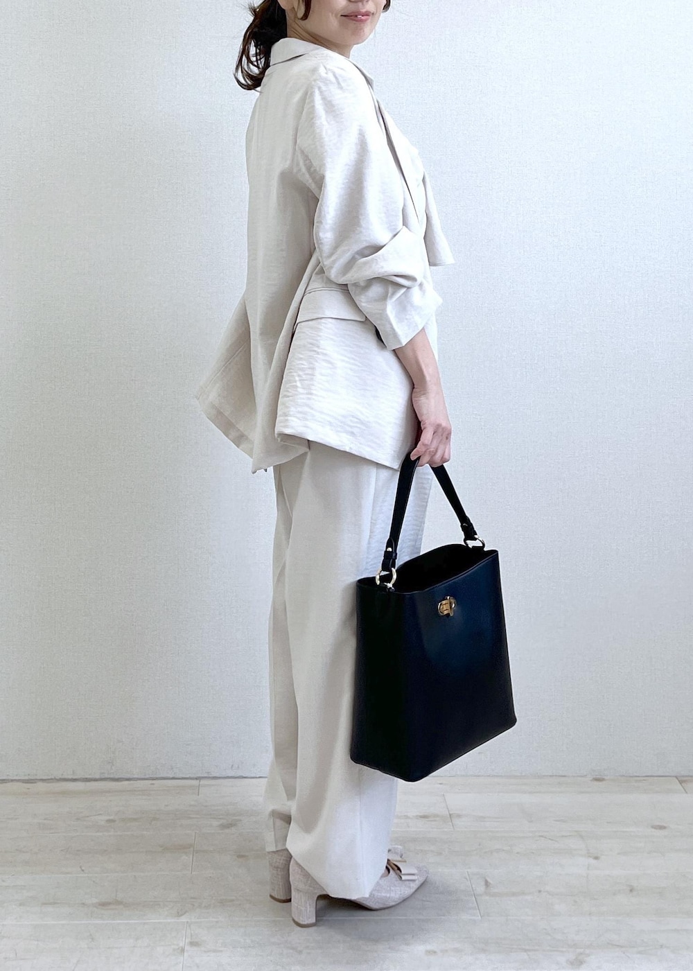 ベージュ系のパンプス、ブラック系のショルダーバッグ、ホワイト系のTシャツ/カットソーを着用したレディースの春コーディネートの2枚目の写真