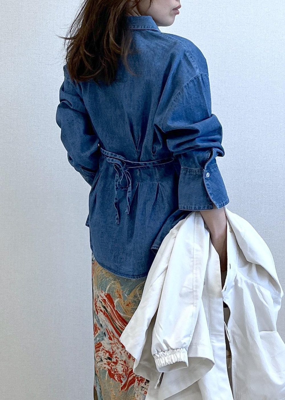 ブラック系のパンプス、ホワイト系のトートバッグ、ホワイト系のナイロンジャケットを着用したレディースの春コーディネートの3枚目の写真