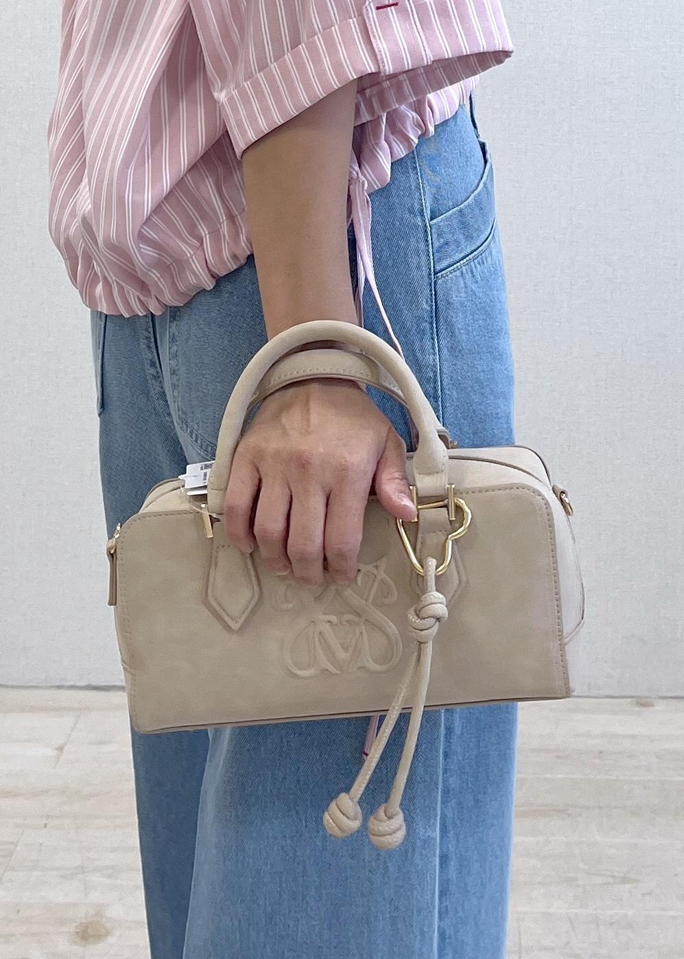 ブラック系のサンダル、ブルー系のデニムパンツ、ベージュ系のボストンバッグを着用したレディースの夏コーディネートの7枚目の写真