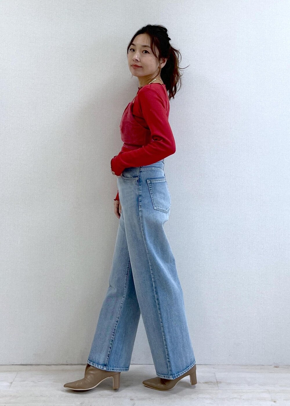 ベージュ系のブーツ、レッド系のキャミソール、レッド系のTシャツ/カットソーを着用したレディースの冬コーディネートの6枚目の写真