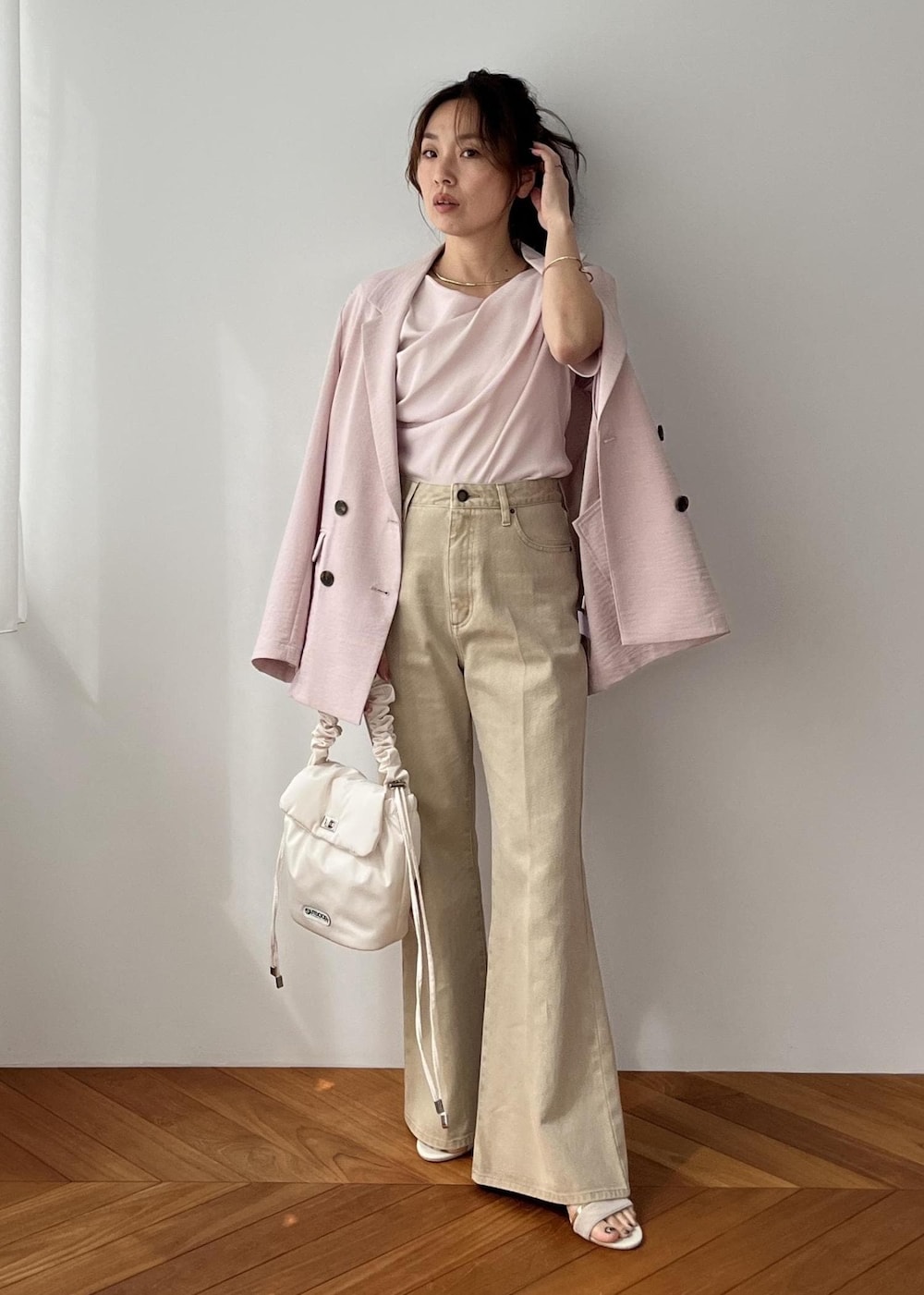 ホワイト系のショルダーバッグ、ピンク系のテーラードジャケット、ベージュ系のデニムパンツを着用したレディースの春コーディネートの5枚目の写真