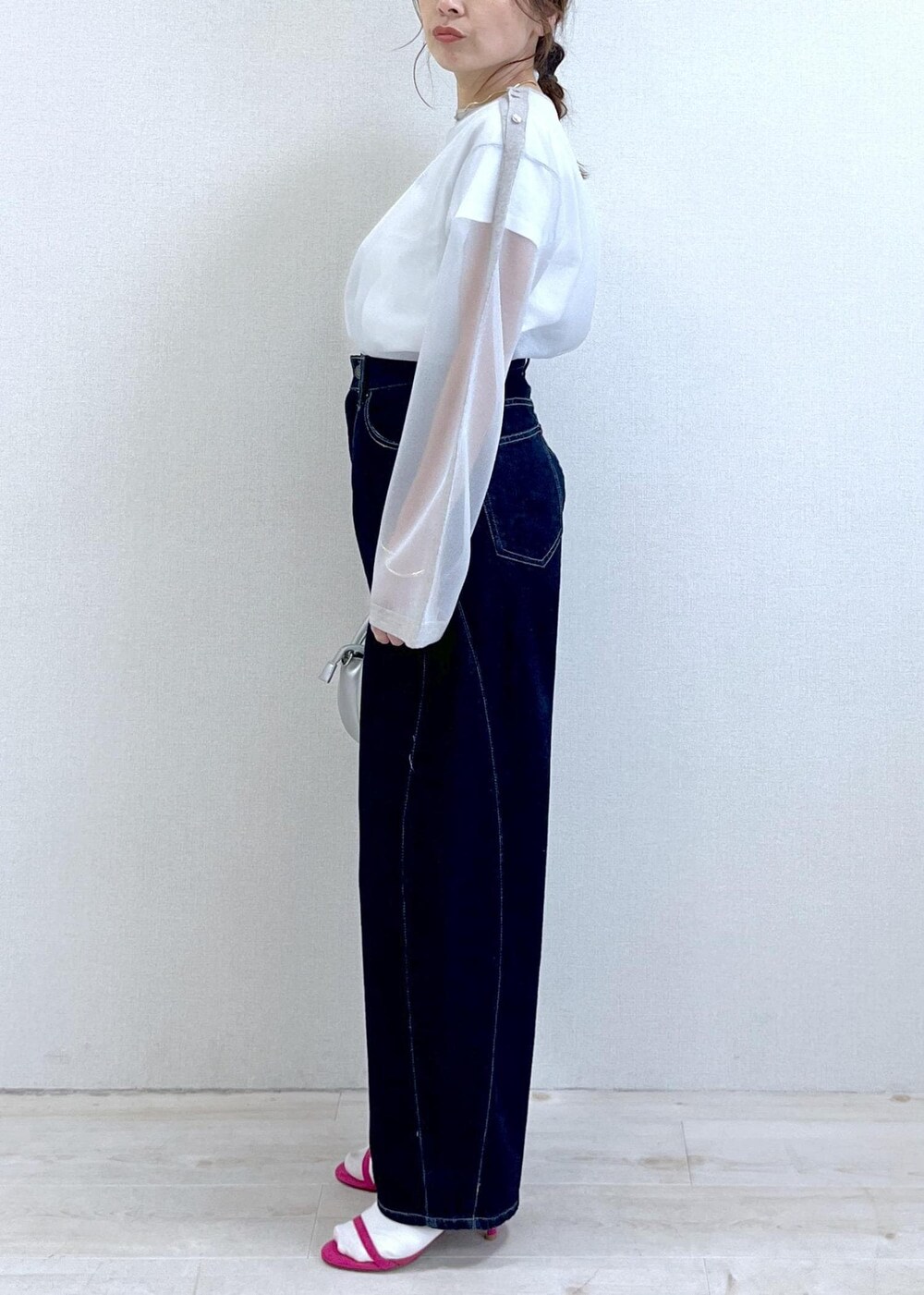 ホワイト系のTシャツ/カットソー、シルバー系のショルダーバッグ、ブルー系のデニムパンツを着用したレディースの春コーディネートの2枚目の写真