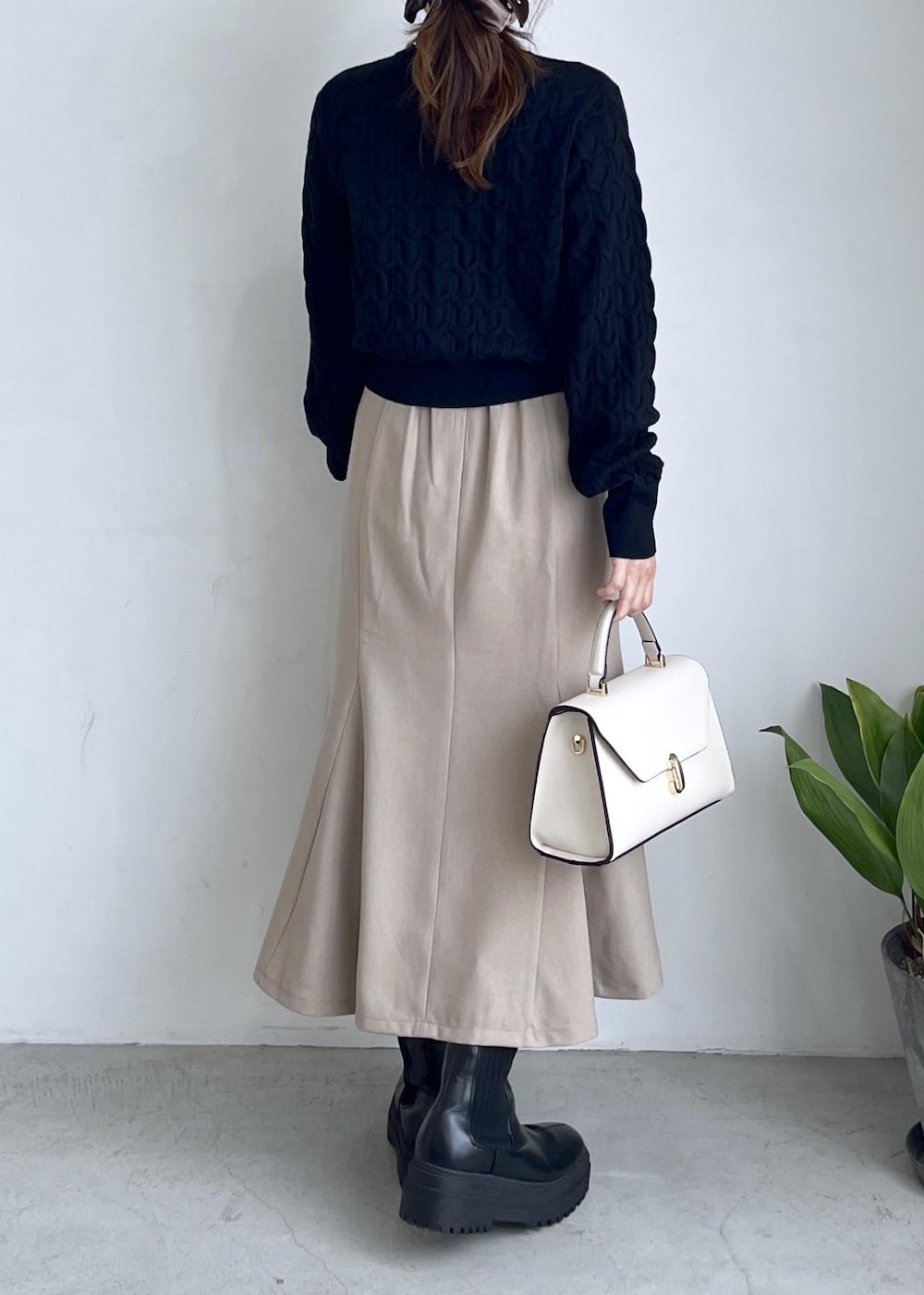 ブラック系のブーツ、ベージュ系のスカート、ブラック系のカーディガン/ボレロを着用したレディースの秋コーディネートの5枚目の写真