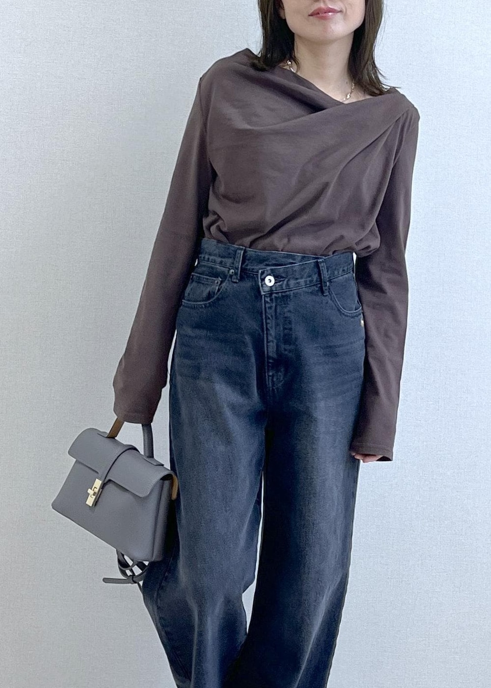 グレー系のショルダーバッグ、ブラウン系のTシャツ/カットソー、グレー系のデニムパンツを着用したレディースの秋コーディネートの2枚目の写真