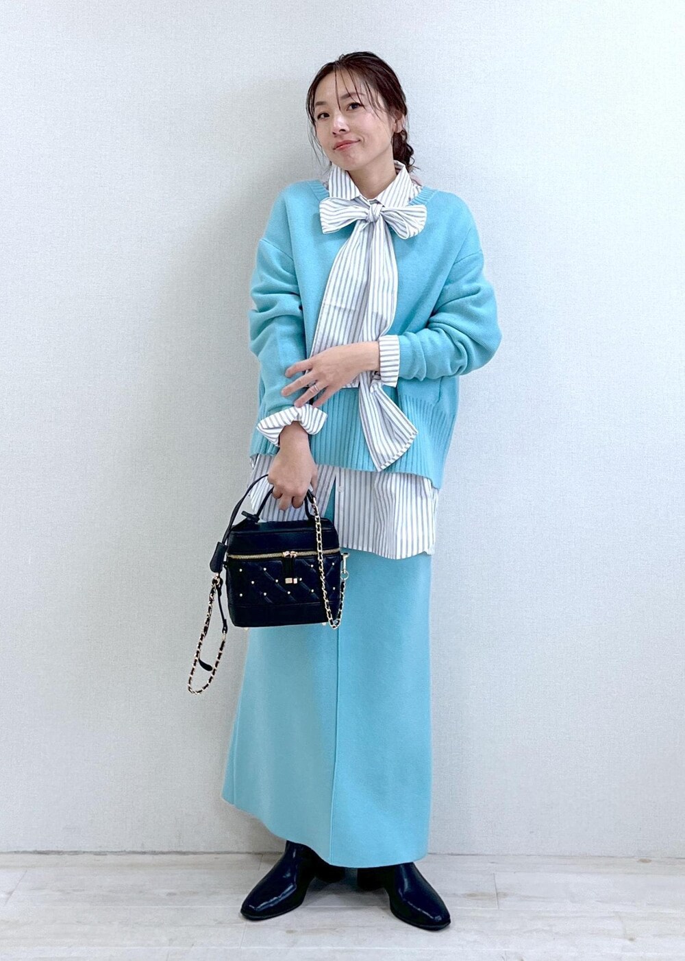 ブラック系のブーツ、ブルー系のスカート、ホワイト系のシャツ/ブラウスを着用したレディースの冬コーディネートの6枚目の写真