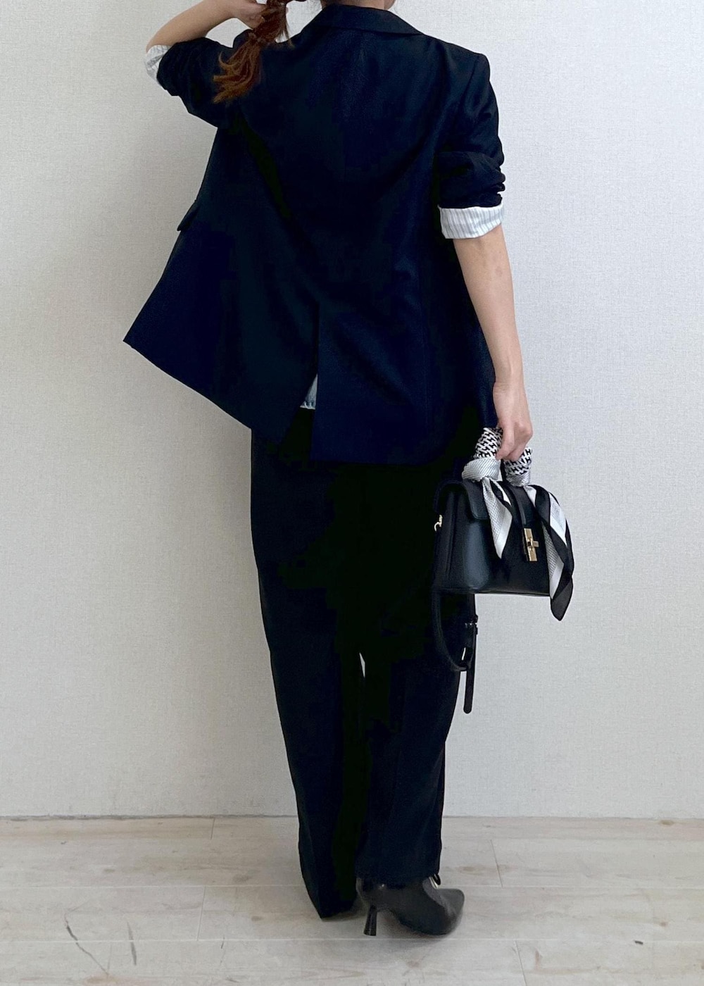 ブラック系のショルダーバッグ、ブルー系のキャミソール、ブルー系のスラックスを着用したレディースの冬コーディネートの4枚目の写真