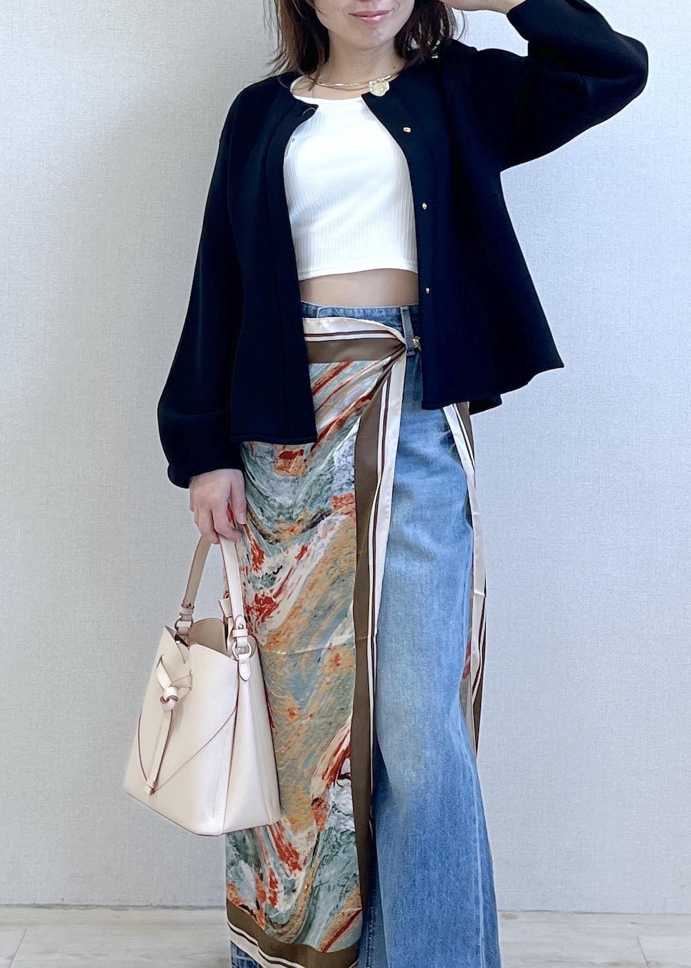 ベージュ系のショルダーバッグ、ブラック系のパンプス、ホワイト系のキャミソールを着用したレディースの春コーディネートの2枚目の写真