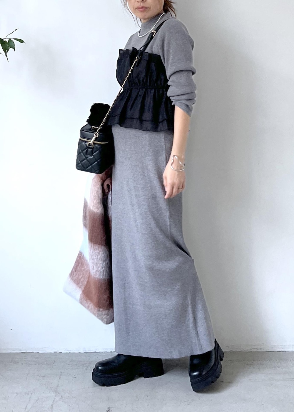 ブラック系のブーツ、グレー系のスカート、グレー系のニット/セーターを着用したレディースの秋コーディネートの4枚目の写真