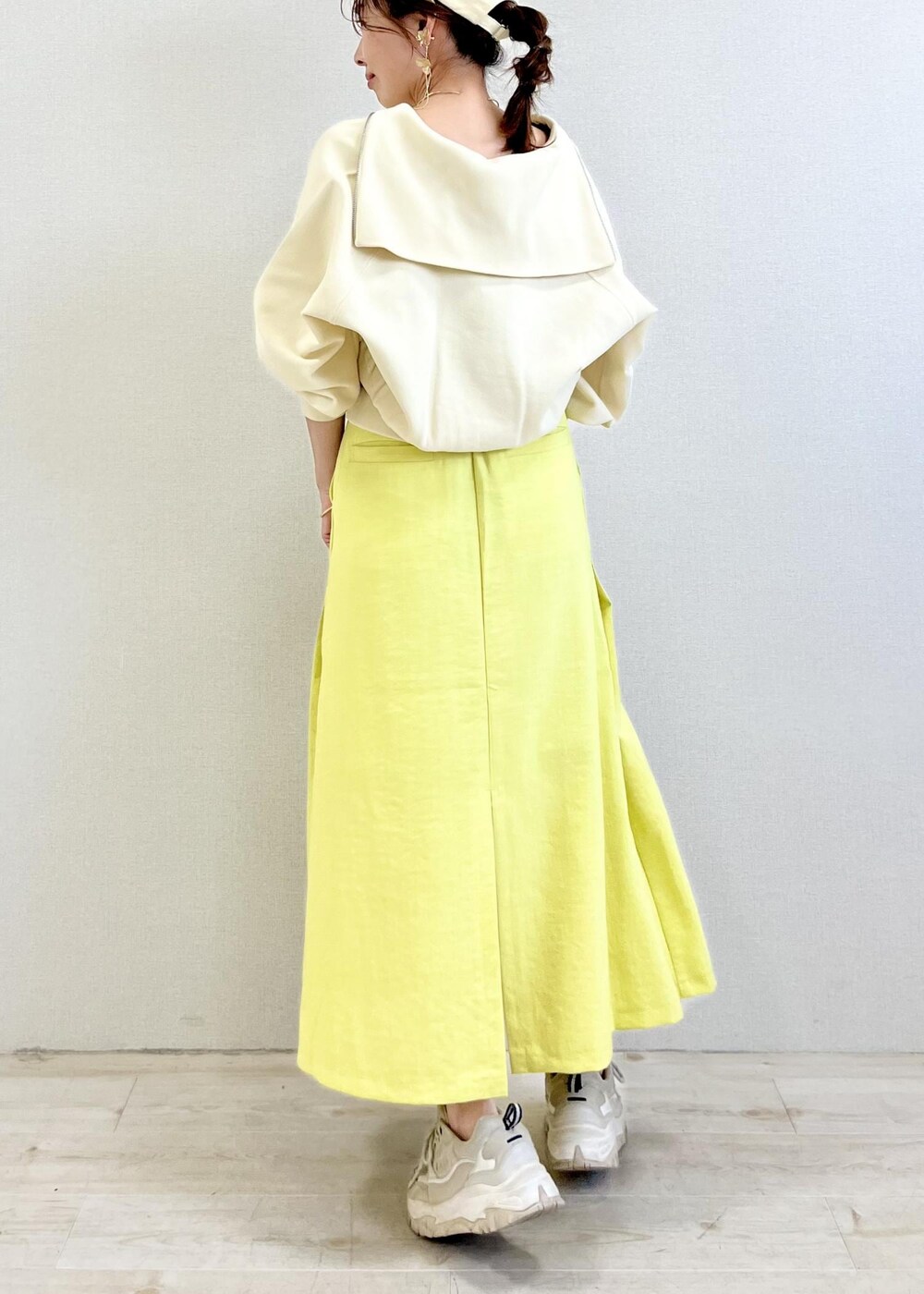 ホワイト系のキャミソール、イエロー系のスカート、ホワイト系のカーディガン/ボレロを着用したレディースの春コーディネートの3枚目の写真