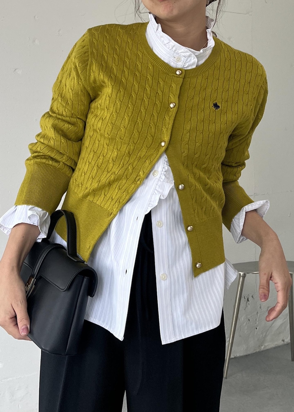 ブラック系のショルダーバッグ、ブラック系のその他パンツ、ホワイト系のシャツ/ブラウスを着用したレディースの秋コーディネートの5枚目の写真