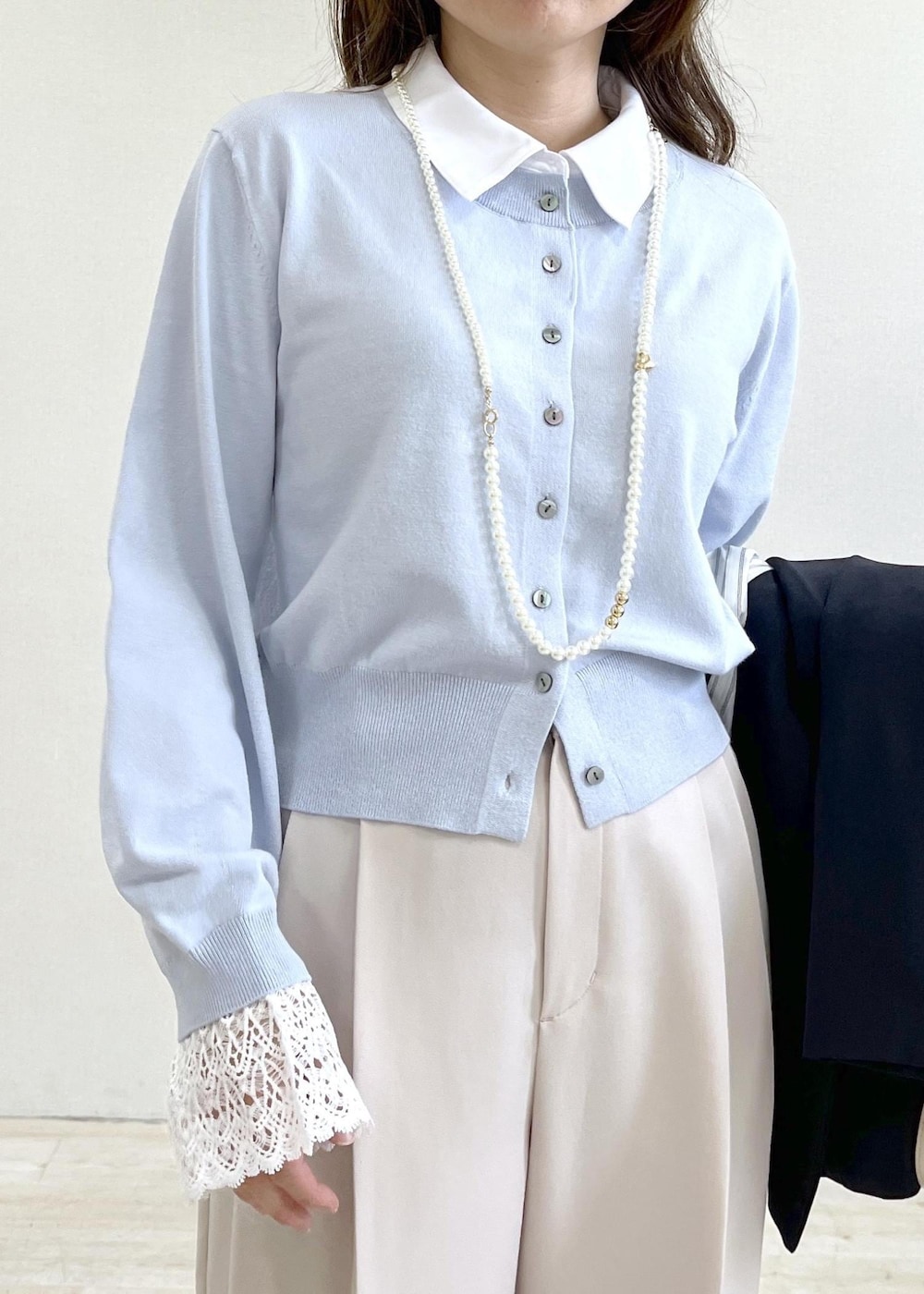 ホワイト系のショルダーバッグ、ブルー系のテーラードジャケット、ベージュ系のその他パンツを着用したレディースの春コーディネートの9枚目の写真