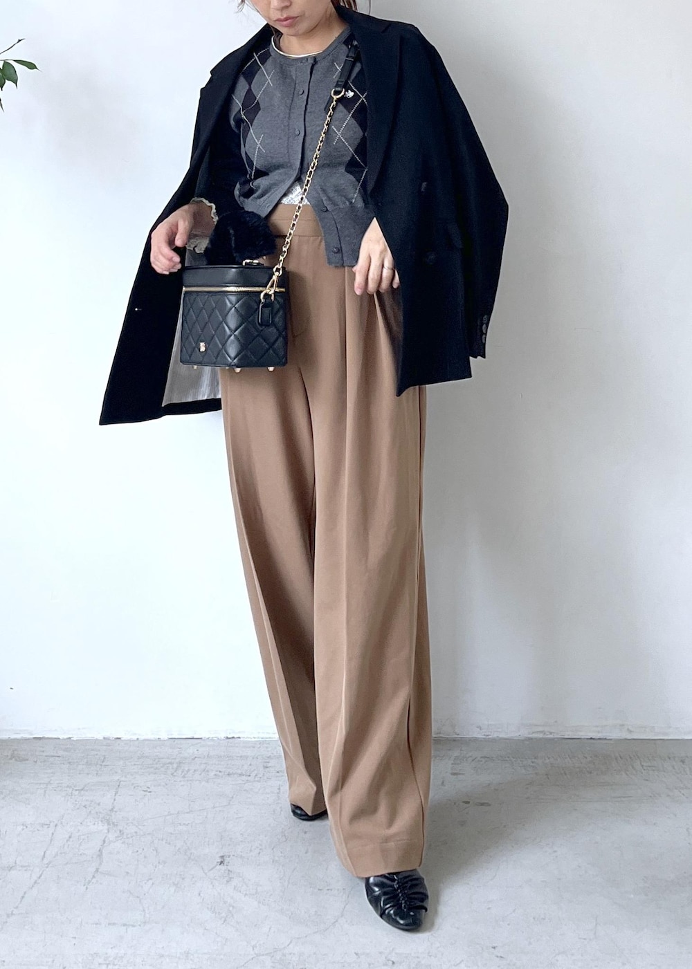 ブラック系のテーラードジャケット、ホワイト系のTシャツ/カットソー、ブラック系のパンプスを着用したレディースの秋コーディネートの2枚目の写真