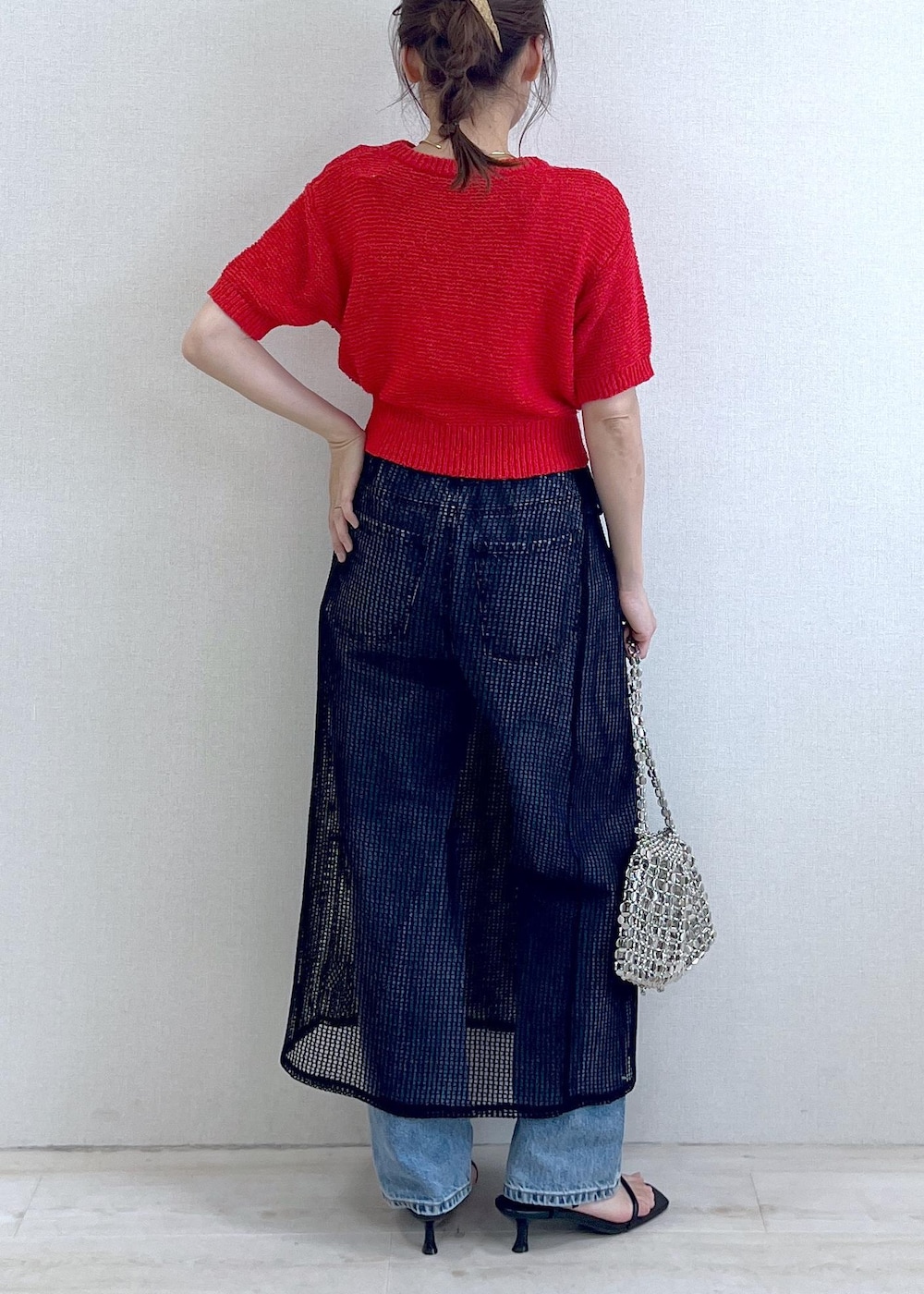シルバー系のショルダーバッグ、ブルー系のデニムパンツ、ブラック系のサンダルを着用したレディースの春コーディネートの2枚目の写真
