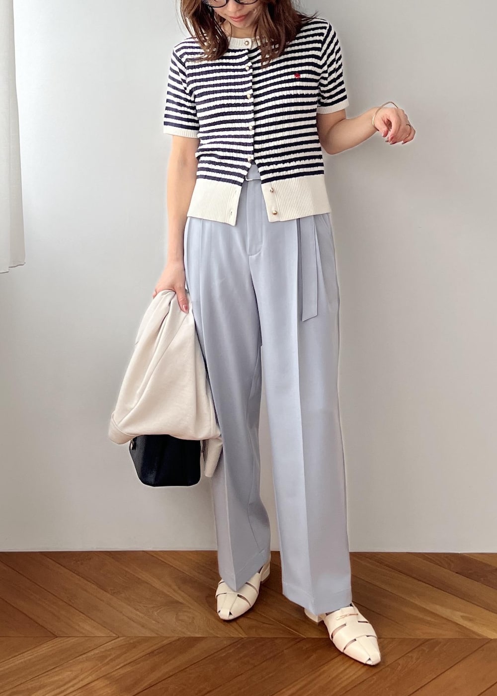 ブラック系のショルダーバッグ、ホワイト系のパンプス、ブルー系のその他パンツを着用したレディースの春コーディネートの8枚目の写真