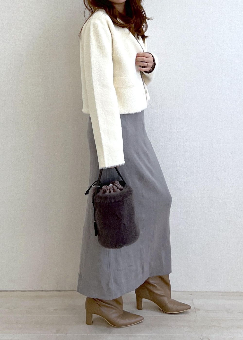 ベージュ系のブーツ、グレー系のショルダーバッグ、ホワイト系のカーディガン/ボレロを着用したレディースの冬コーディネートの3枚目の写真