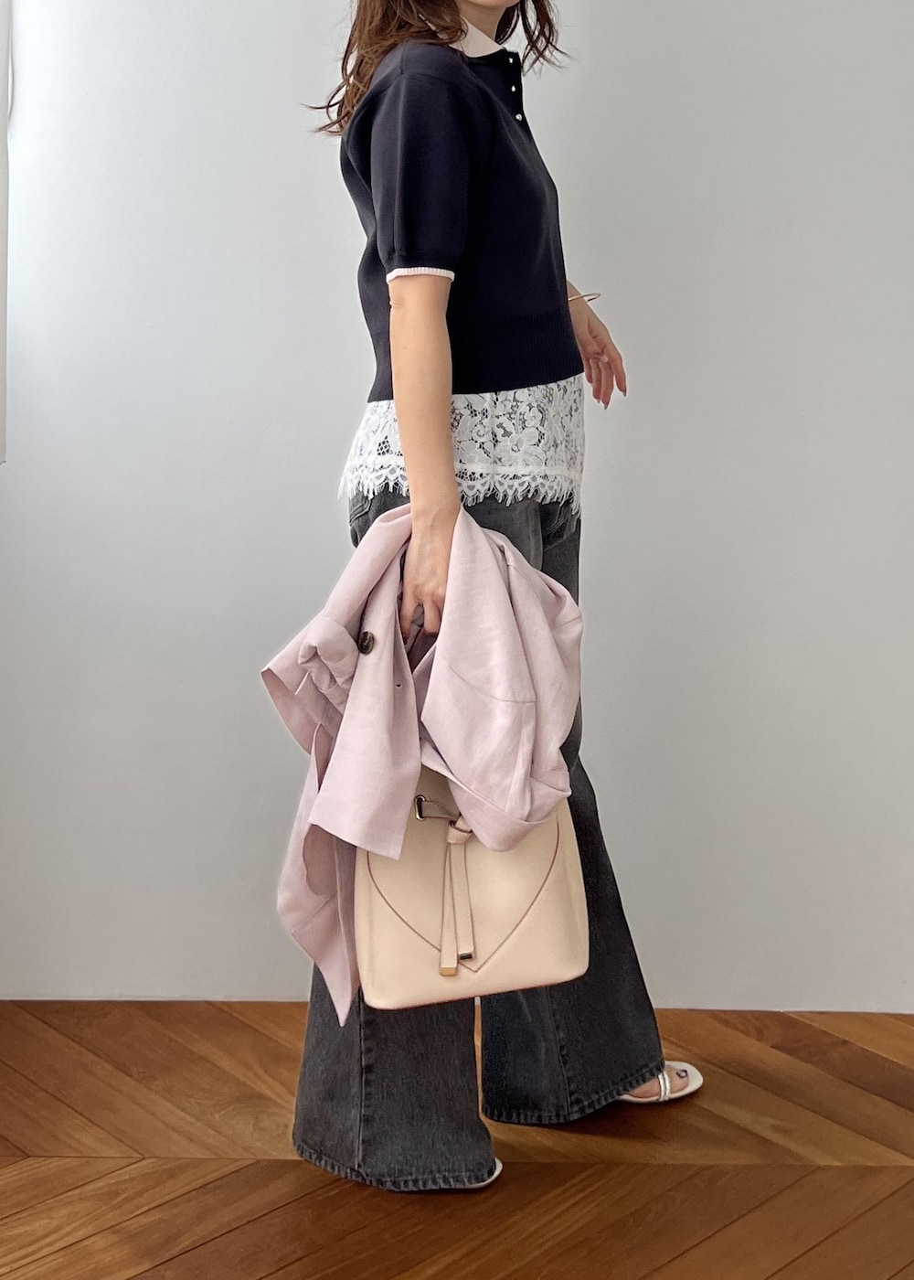 ベージュ系のショルダーバッグ、ピンク系のテーラードジャケット、グレー系のポロシャツを着用したレディースの春コーディネートの2枚目の写真